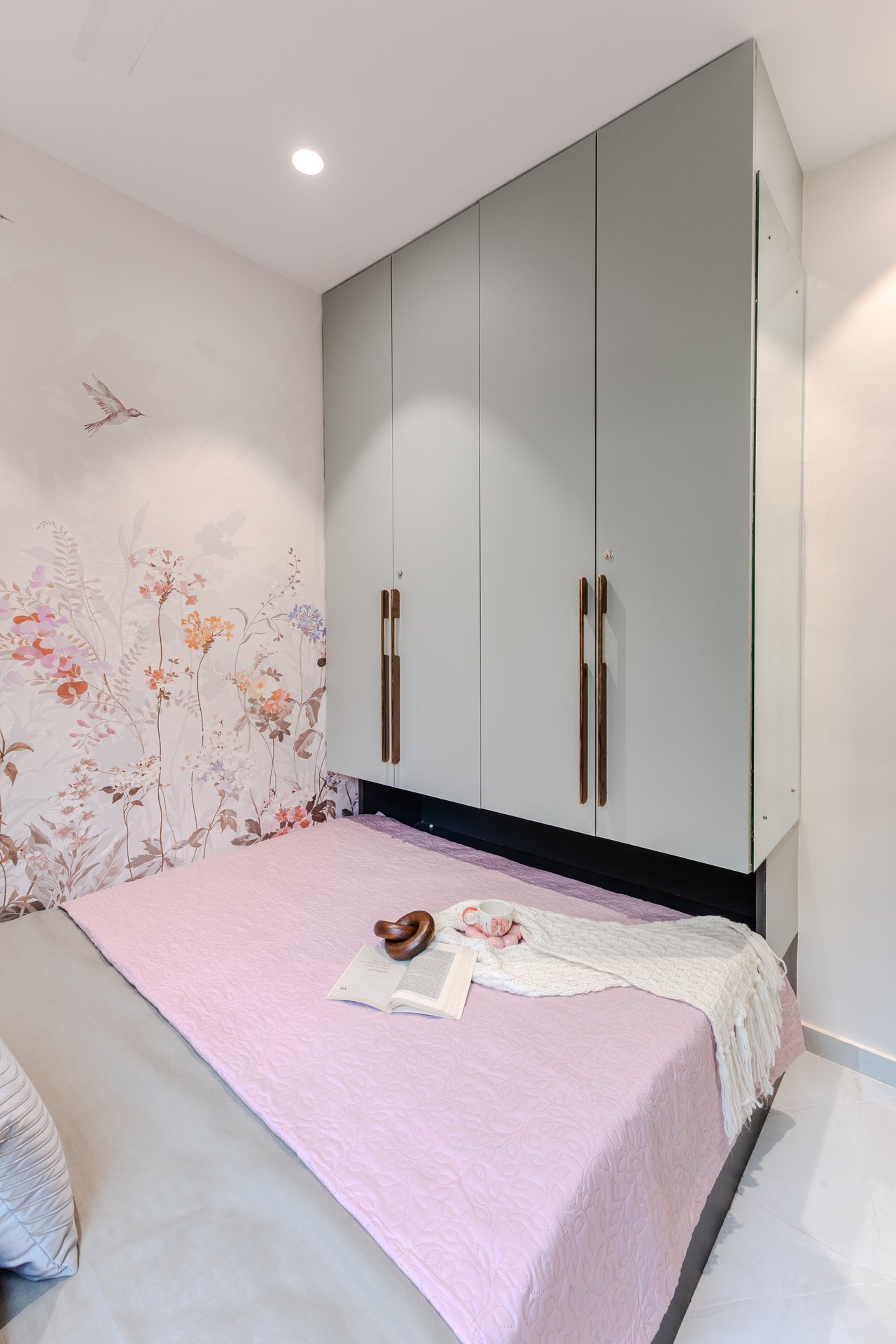 Built-in overhead storage and floral accent guest room by Design DNA
